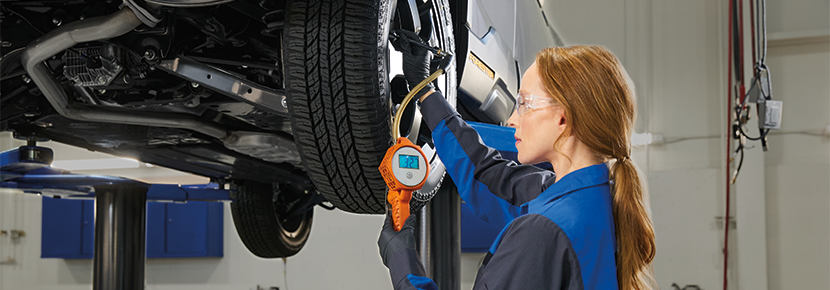 A Subaru technician checking tire pressure. | Dellenbach Subaru in Fort Collins CO